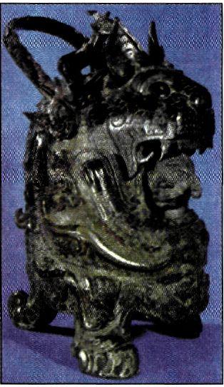 Τελετουργικό ορειχάλκινο σκεύος της δυναστείας των Σάνγκ (14ος-11ος αι. π.Χ.). Έχει τη μορφή τίγρης που προστατεύει έναν άνδρα. Όλη η επιφάνεια του σκεύους είναι καλυμμένη με ζωικά σχέδια που έχουν σχέση με τη γονιμότητα.